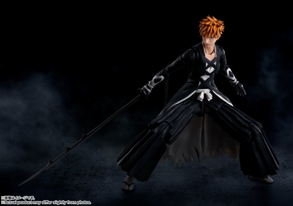 Action figure with long black coat and red hair against a dark background