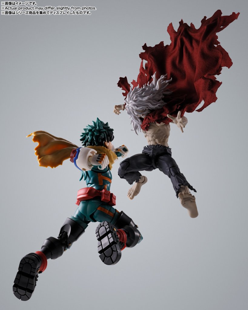 Two action figures in dynamic poses against a gray background